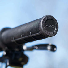 Load image into Gallery viewer, Close-up of a black bicycle handlebar grip Gridlock with 'DMR' branding against a blue sky.